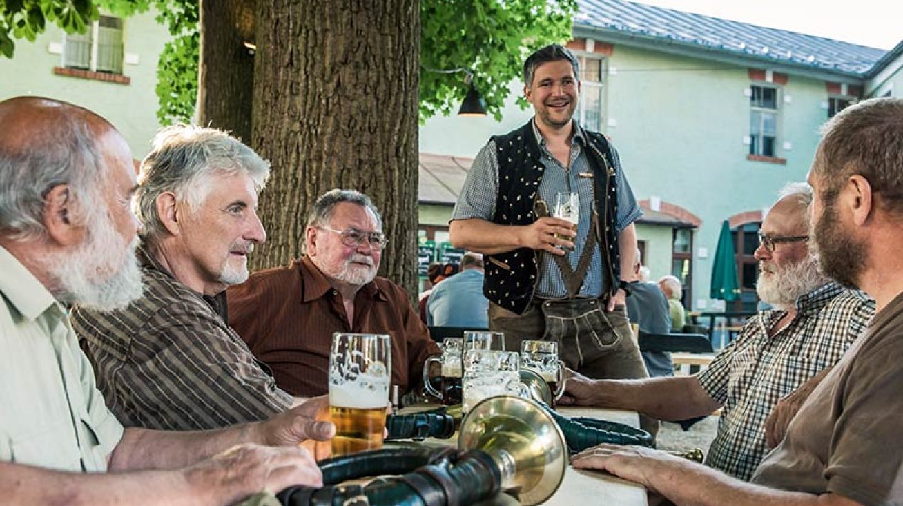 Gäste im Biergarten der Gaststätte Röhrl unter alten Kastanien